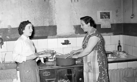 Dos mujeres cocinando en un fogón de leña, fotografía de archivo